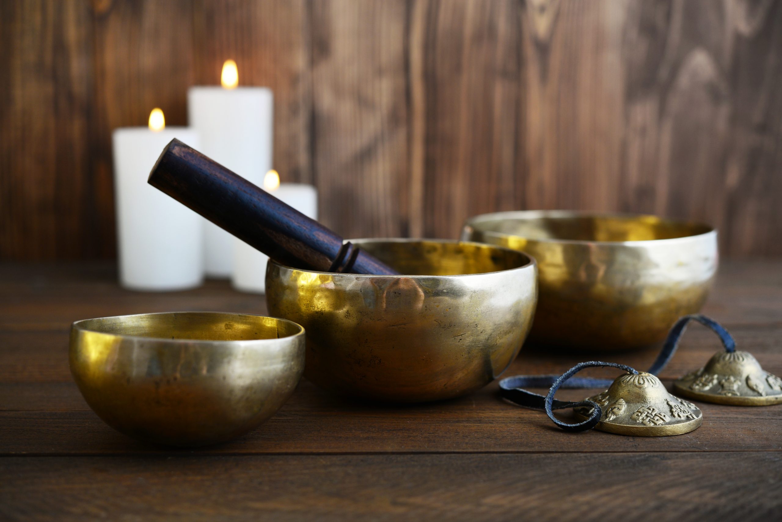 Tibetan handcrafted singing bowls with sticks on wooden background