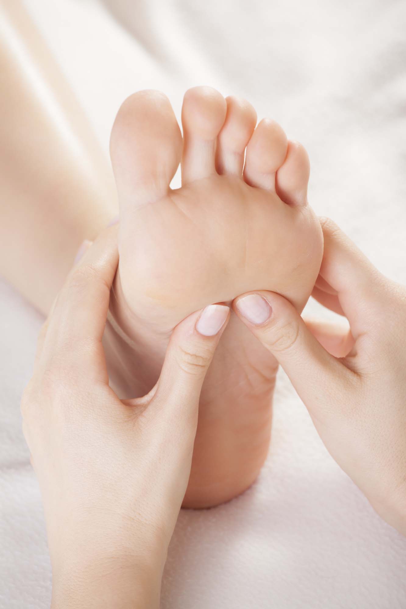 hands massaging a foot on white background